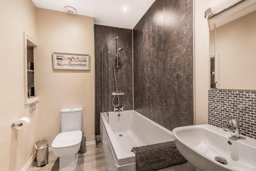 a bathroom with a tub and a toilet and a sink at Great Gate House View, Micklegate near York Station in York
