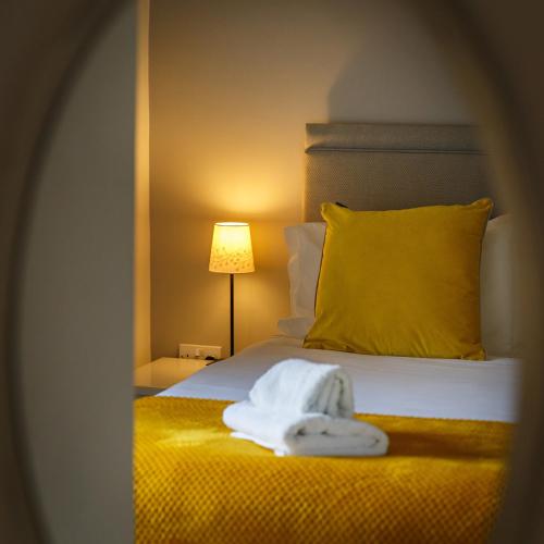 a hotel room with a bed with a yellow pillow at Chestnut Cottage in Felbrigg