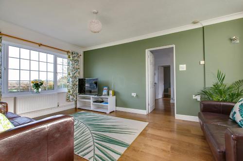 a living room with a couch and a television at Chestnut Cottage in Felbrigg