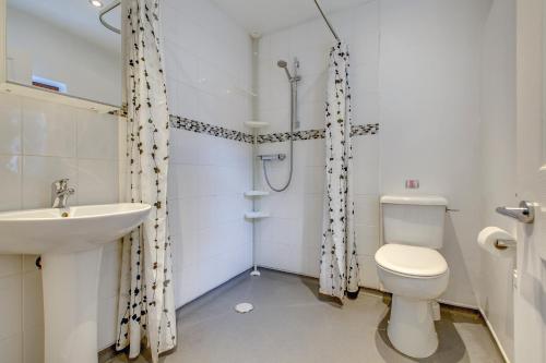a bathroom with a toilet and a sink at Chestnut Cottage in Felbrigg