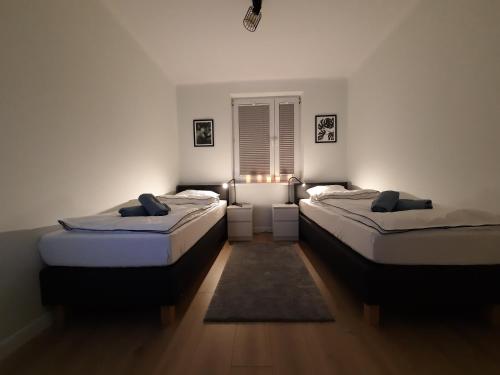 two twin beds in a room with a window at Apartament Sunny Home in Nowy Targ