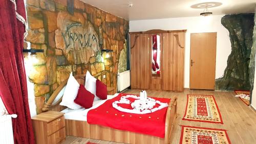 una camera con un letto di fronte a un muro di pietra di Complex Dracula & Spa a Căpăţîneni-Ungureni
