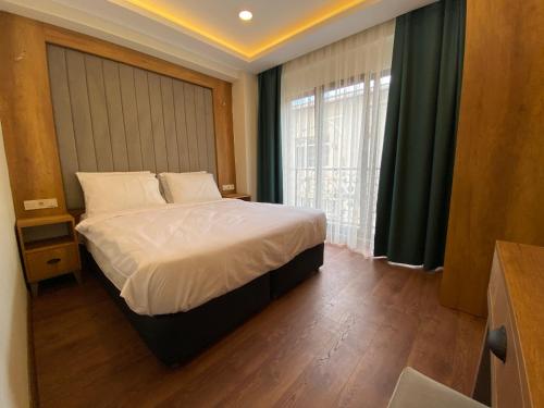 a bedroom with a bed and a large window at Pege Hotel in Istanbul