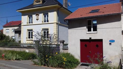 una casa blanca y roja con una puerta roja en Studio rénové et équipé 2 personnes Le canardeau, en Ancy-sur-Moselle