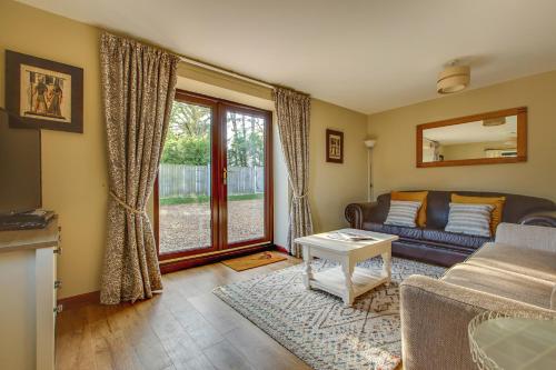 a living room with a couch and a table at Anvil & Stable Cottages in Felbrigg