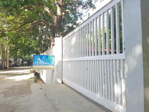 a white fence with a sign in front of it at R&;S Restplace Resort in Matabungkay