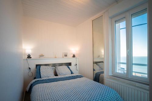 Schlafzimmer mit einem Bett und Meerblick in der Unterkunft La tête Ault - Une expérience unique en bord de Mer in Ault
