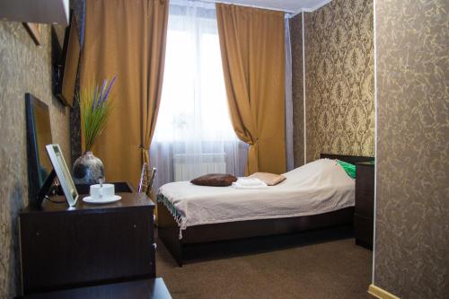 a small bedroom with a bed and a window at Авеню in Surgut