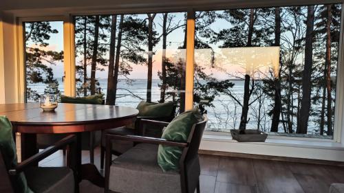 a dining room with a table and a large window at Seaside cottage Rebase Kuur in Keibu