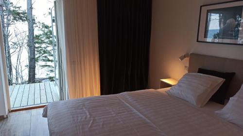 a bedroom with a bed and a large window at Seaside cottage Rebase Kuur in Keibu