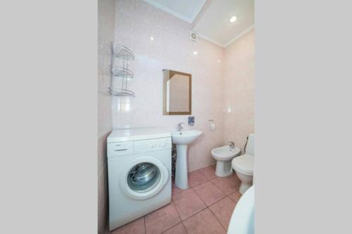 uma casa de banho com uma máquina de lavar roupa e um lavatório em Солнечные апартаменты на Крещатике em Kiev