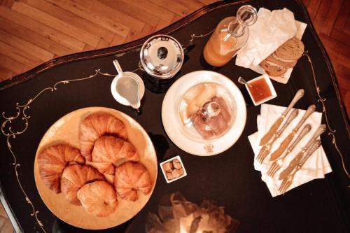 a table with a bowl of croissants and a plate of bread at Le Chai in Condom
