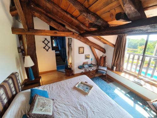 a bedroom with a bed and a large window at Domaine de Millox in Saint-André-de-Seignanx