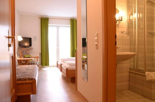 a room with a bathroom with a bed and a sink at Waldhotel Twiehaus Garni in Lübeck