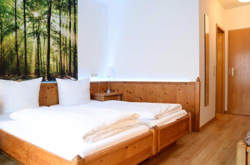 a bedroom with a bed with a window with trees at Waldhotel Twiehaus Garni in Lübeck