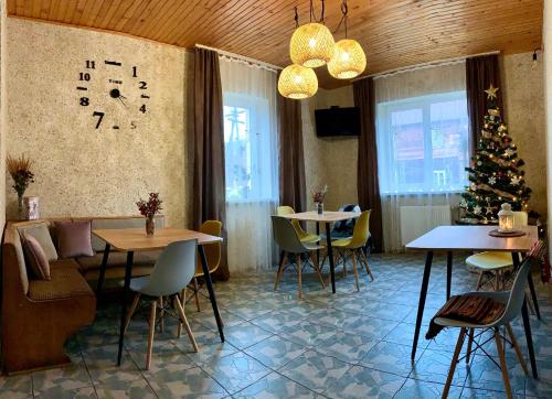a dining room with two tables and a christmas tree at Ніч над Карпатами in Slavske