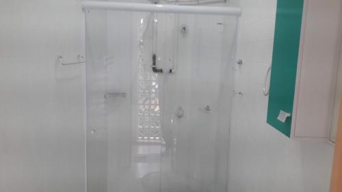 uma casa de banho com um chuveiro e uma porta de vidro em JASMIM em São Paulo