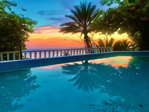 a swimming pool with a sunset in the background at CafeGourmetPtaCorona in San Carlos