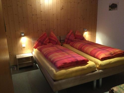 two twin beds in a room with two lamps at Chalet Marder in Riederalp