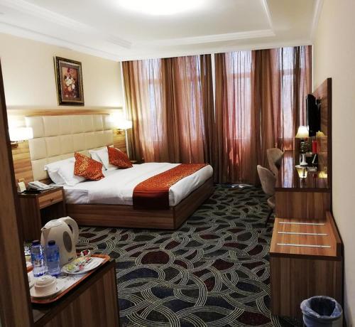 ジッダにあるRoshan Al Azhar Hotelのベッドとデスクが備わるホテルルームです。