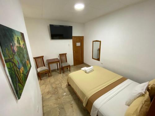 a bedroom with a bed and a table and chairs at Fitzcarrald Hotel in Iquitos