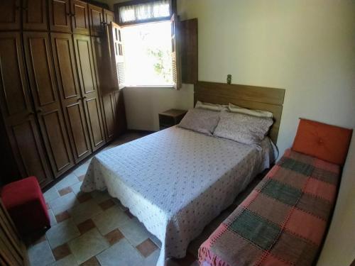een slaapkamer met een bed en een raam bij Residência Guarujá Praia Pernambuco Condomínio Fechado in Sao Paulo