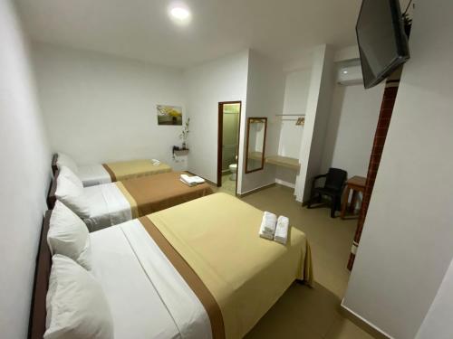 um quarto de hotel com duas camas e uma televisão de ecrã plano em Fitzcarrald Hotel em Iquitos