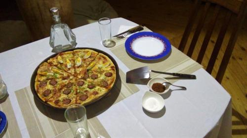 a pizza sitting on top of a table at La Frontera Bed & Breakfast, Valle Cochamó in Cochamó