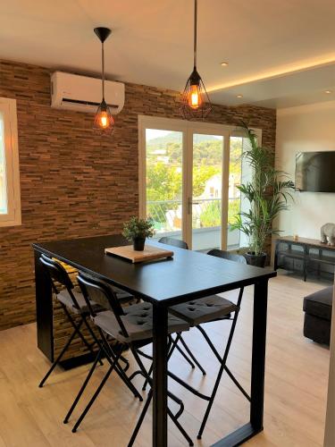 une salle à manger avec une table et des chaises noires dans l'établissement Confort à Carqueiranne, à Carqueiranne
