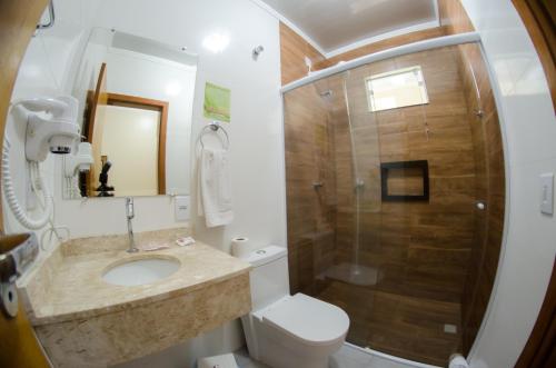 a bathroom with a toilet, sink, and shower at Villarejo Parque Hotel in Penha