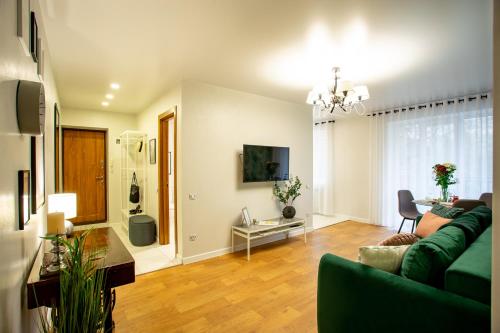 - un salon avec un canapé vert et une table dans l'établissement Luxury Apartment with 2 bedrooms in the city center, à Mykolaïv