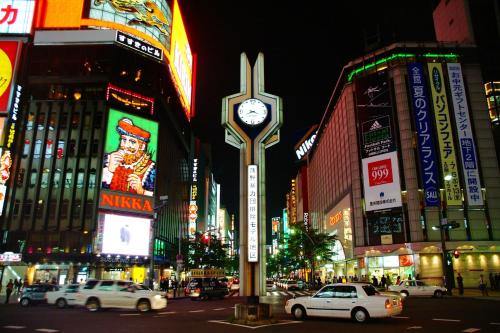 a clock on a pole on a city street at night at Keio Plaza Hotel Sapporo in Sapporo