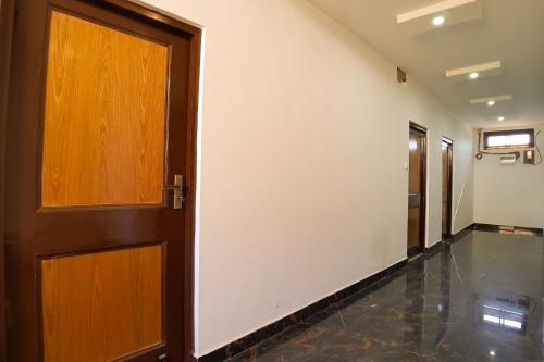 an empty hallway with a wooden door and a room at Grand Kailash Khajjiar in Dalhousie