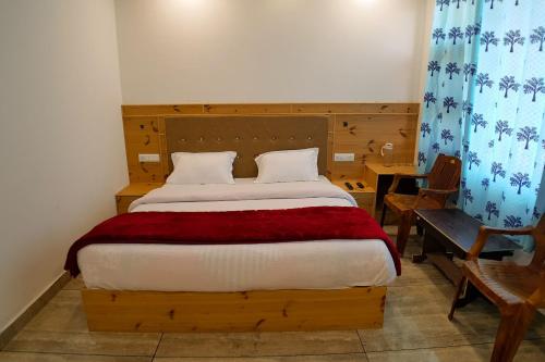 a bedroom with a bed with a red blanket at Grand Kailash Khajjiar in Dalhousie