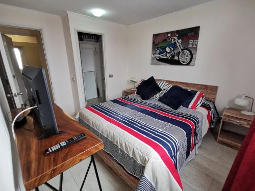 1 dormitorio con 1 cama y mesa con TV en Departamento en Avenida Del Mar en La Serena