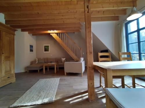 una sala de estar con techos de madera y una escalera. en Forsthaus Goldberg, en Bad Harzburg
