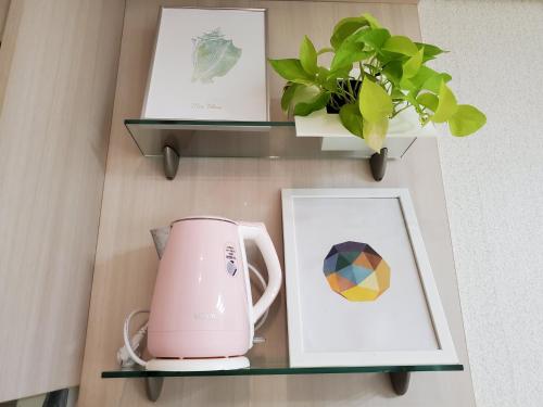 a shelf with a tea kettle and pictures on it at Warm Studio in Incheon