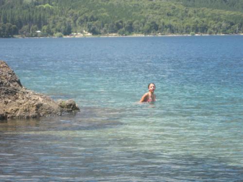a woman swimming in a large body of water at Domos Puelo in Lago Puelo