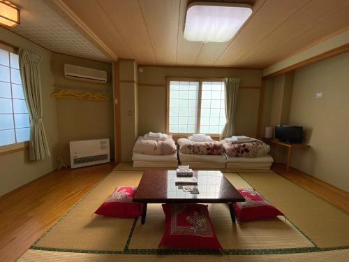 a living room with a table and a couch at Nozawa Dream Central in Nozawa Onsen
