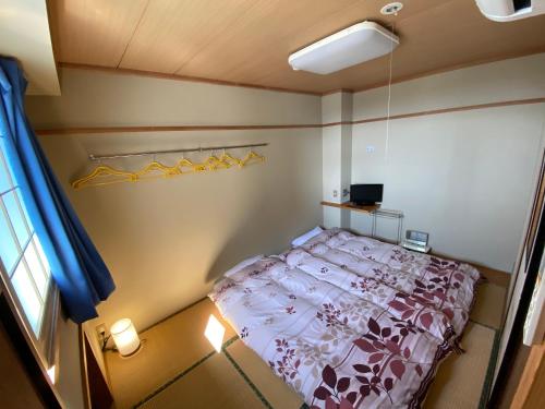 a small bedroom with a bed and a window at Nozawa Dream Central in Nozawa Onsen