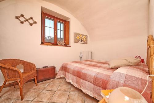 a bedroom with a bed and a chair and a table at Il Colombaro in Salò