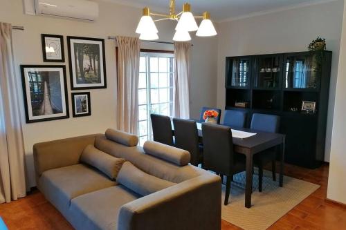 a living room with a couch and a dining room table at Refúgio do Seixoso in Celorico de Basto