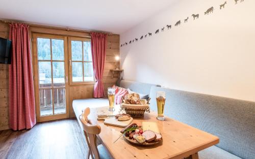 una habitación con una mesa con un plato de comida y bebida en Haus Pfannenhölzer, en Bad Hindelang