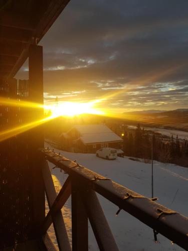 a winter sunset with the sun setting behind a building at Åre-Bjørnen Falken 17A in Åre