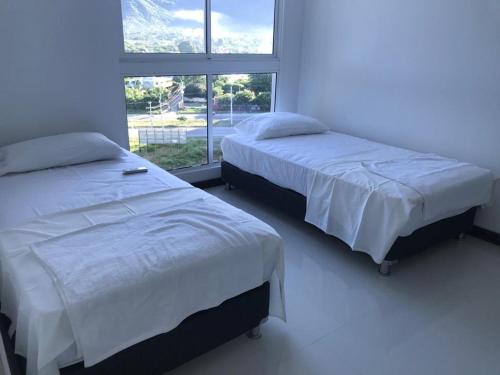 Ένα ή περισσότερα κρεβάτια σε δωμάτιο στο Hermoso Apto con vista a la sierra y a Cabo Tortuga en el sector del Irotama en Santa Marta