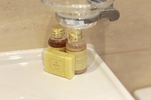 two bottles of honey sitting on top of a sink at London Central Apartments in London