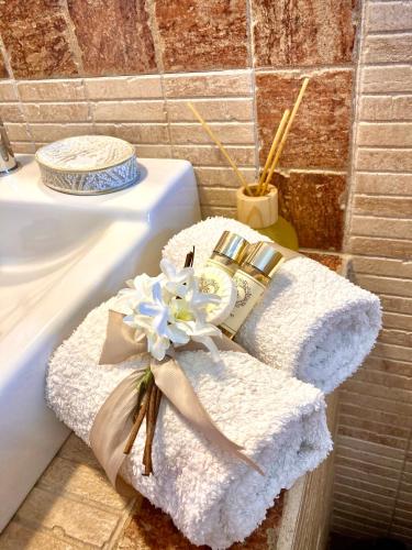 a white towel with a flower on top of a sink at Herdade Monte Do Sol in Aljezur