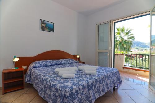 a bedroom with a bed and a large window at Casamareblu in Parghelia