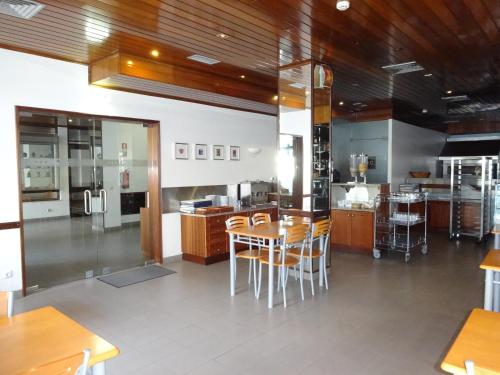 eine Küche mit Holzschränken sowie einem Tisch und Stühlen in der Unterkunft Estalagem Sequeira in São Brás de Alportel