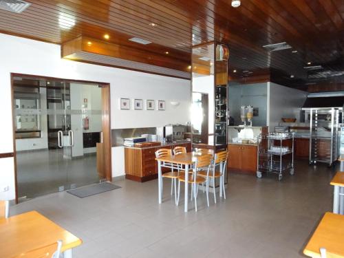 a kitchen with wooden cabinets and a table and chairs at Estalagem Sequeira in São Brás de Alportel